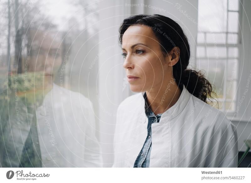 Female doctor standing at the window, looking worried human human being human beings humans person persons caucasian appearance caucasian ethnicity european 1