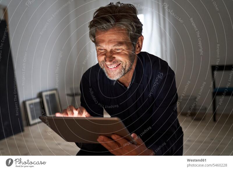 Portrait of smiling mature man having fun with digital tablet at home business life business world business person businesspeople Business man Business men