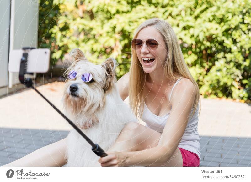 Happy woman taking a selfie with her dog wearing sunglasses Germany playful wireless Wireless Connection Wireless Technology Wireless Communication carefree