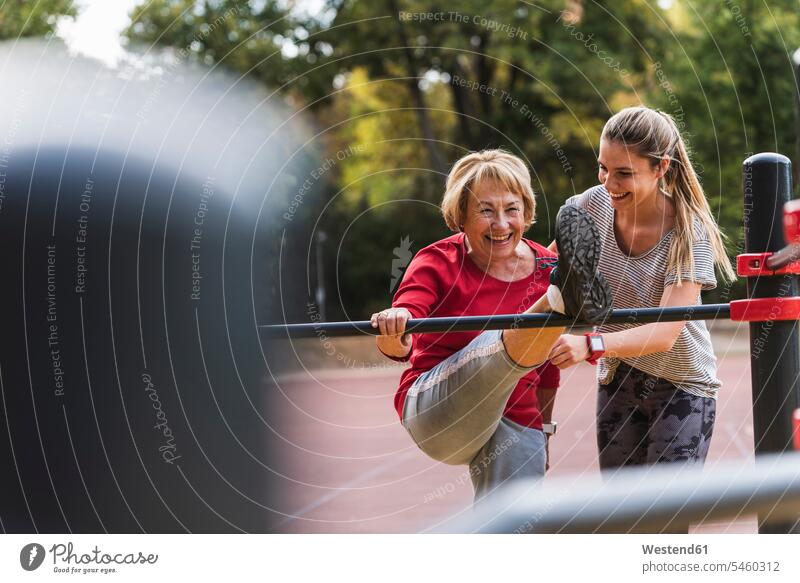 Grandmother and granddaughter training on bars in a park exercising exercise practising parks Strength strong Force Strengthy Power Flexibility flexible