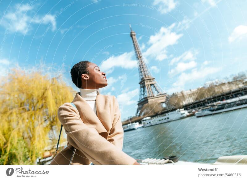 France, Paris, Woman with closed eyes at river Seine with the Eiffel Tower in the background River Rivers woman females women female tourist water waters