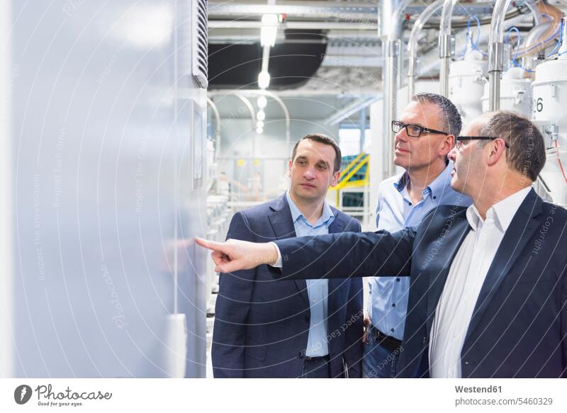 Three businessmen having a discussion in a factory human human being human beings humans person persons caucasian appearance caucasian ethnicity european Group