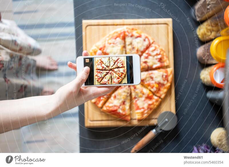 Crop view of woman taking photo of homemade pizza with smartphone cell phone cell phones Cellphone mobile mobile phones mobiles Device Screen Device Screens