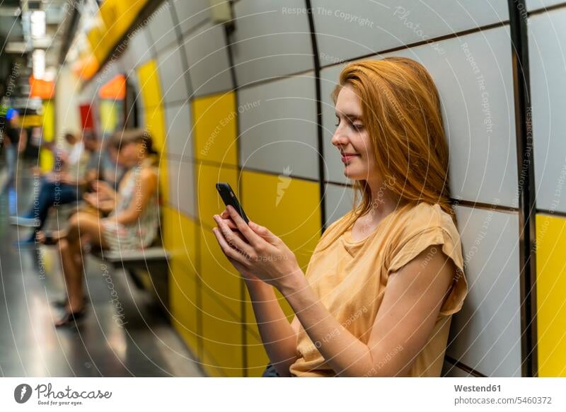 Woman using smartphone in underground station T- Shirt t-shirts tee-shirt telecommunication phones telephone telephones cell phone cell phones Cellphone mobile