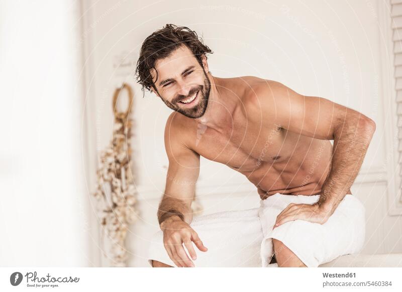 Shirtless young man in a badroom bath tub bath tubs bathtubs towels bath robe bath robes bathrobes Bed - Furniture beds relax relaxing smile Seated sit