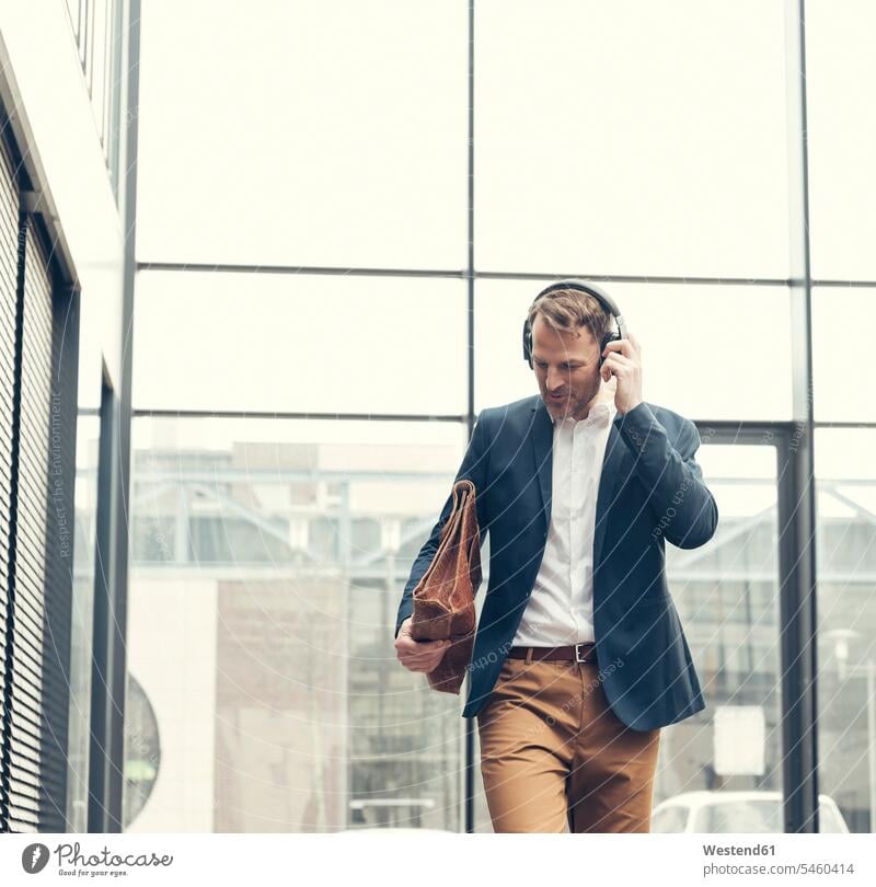 Smiling businessman listening to music with headphones Businessman Business man Businessmen Business men smiling smile hearing headset business people