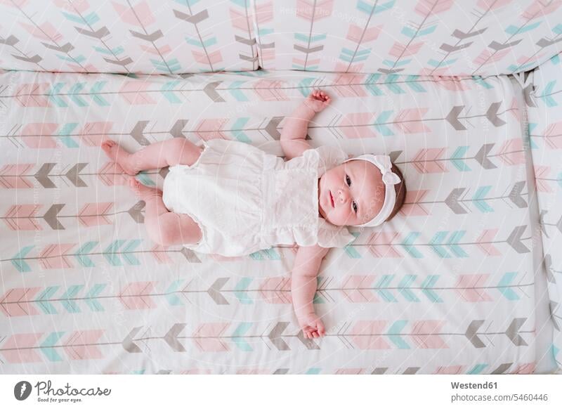 Cute baby girl lying in crib at home color image colour image indoors indoor shot indoor shots interior interior view Interiors day daylight shot daylight shots