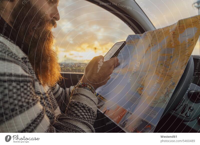 Man using smartphone in car, looking at map for directions man men males maps Exploration exploring explore Iceland Traveller Travellers Travelers Smartphone
