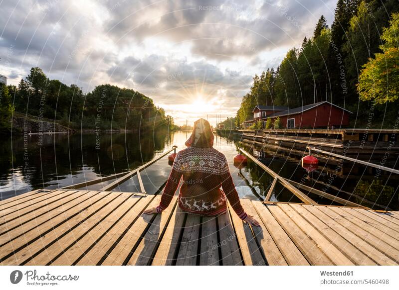 Finland, Kajaani, Man sitting on jetty, watching sunset, rear view relaxation relaxing back view view from the back sunsets sundown landing stage landing stages