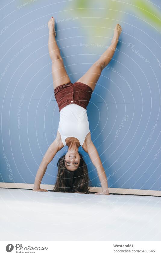 Young woman doing handstand against wall handstands young women young woman fitness Strength strong Force Strengthy Power walls females Adults grown-ups