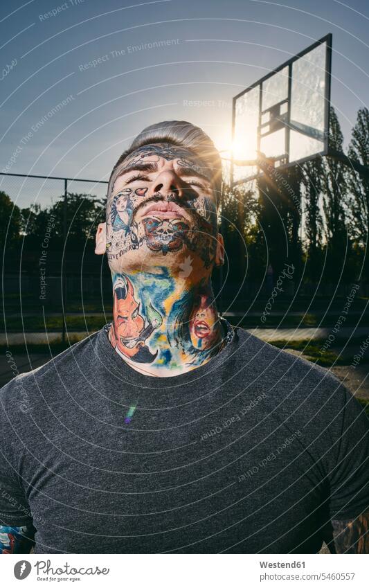 Portrait of tattooed young man on basketball court portrait portraits sports field sports fields tattoos basketball ground men males body art Body Adornment