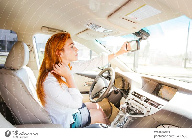 Business woman in a car checking her look in the rear-view mirror seeing viewing indoor indoor shot indoor shots interior interior view Interiors human