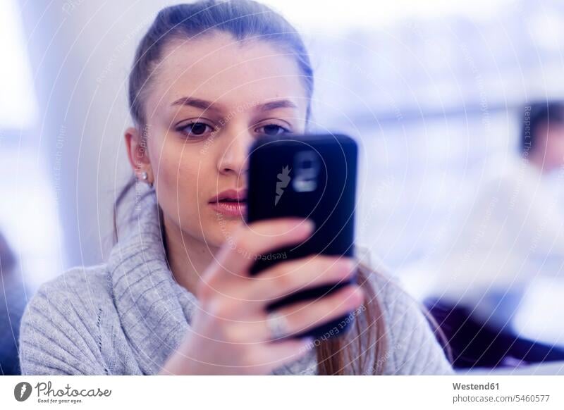 Portrait of young woman using smartphone use portrait portraits office offices office room office rooms females women Smartphone iPhone Smartphones workplace