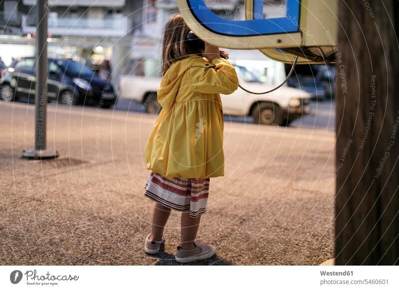 Back view of little girl using telephone booth females girls telephone box telephone kiosk callbox use child children kid kids people persons human being humans