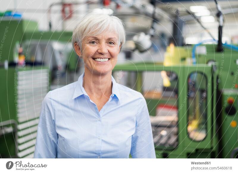 Portrait of smiling senior businesswoman in a factory factories smile portrait portraits businesswomen business woman business women confidence confident