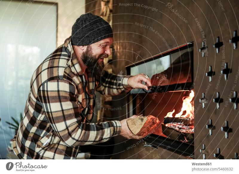 Happy bearded man in front of fireplace at home happiness happy Fire Place fireside men males Adults grown-ups grownups adult people persons human being humans