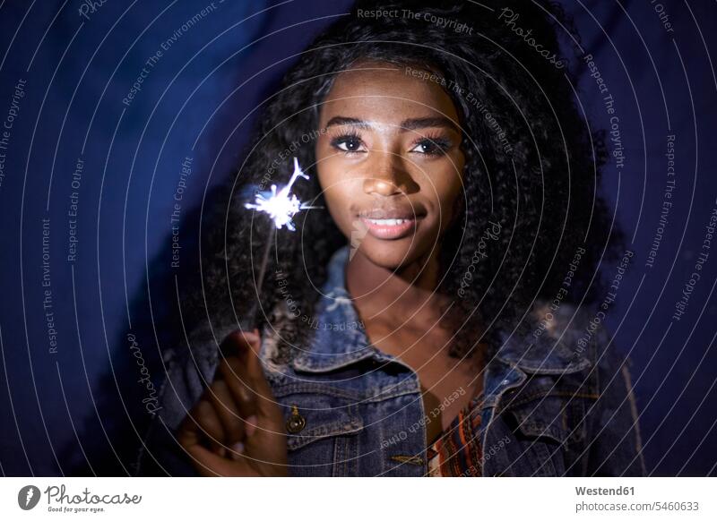 Portrait of smiling young woman with sparkler human human being human beings humans person persons African black black ethnicity coloured 1 one person only