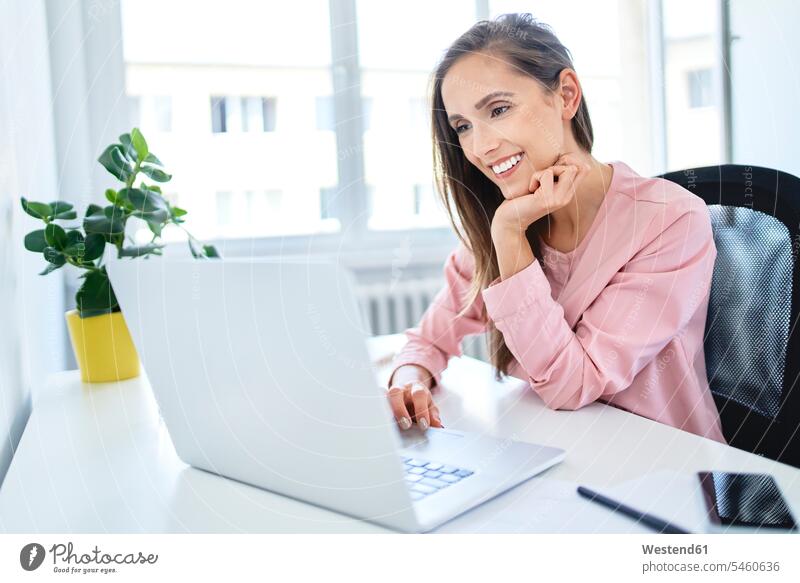 Happy young businesswoman working with laptop in office Occupation Work job jobs profession professional occupation business life business world business person