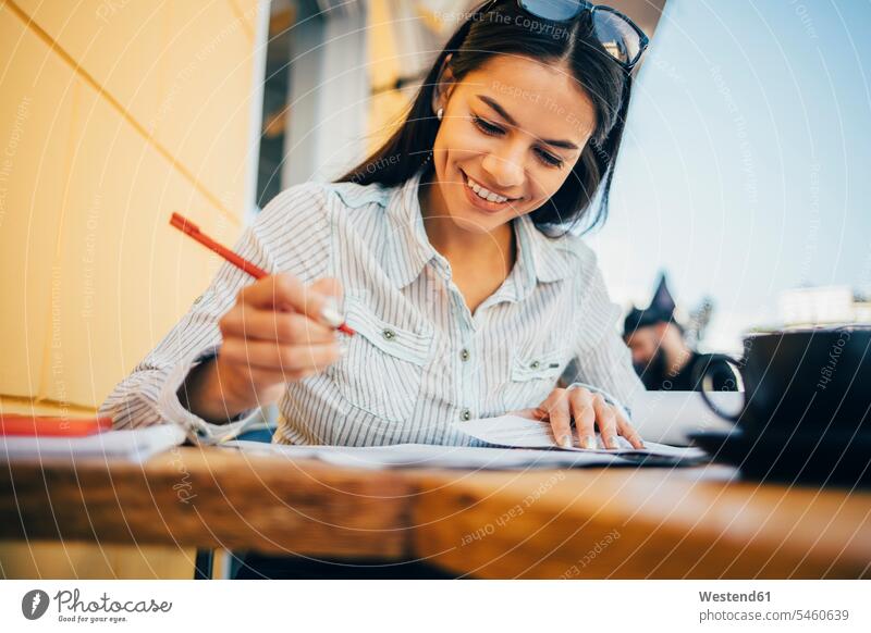 Smiling young woman taking notes in a cafe human human being human beings humans person persons 1 one person only only one person adult grown-up grown-ups