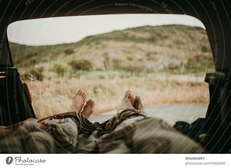 Tired mid adult couple lying in car trunk color image colour image Spain day daylight shot daylight shots day shots daytime leisure activity leisure activities