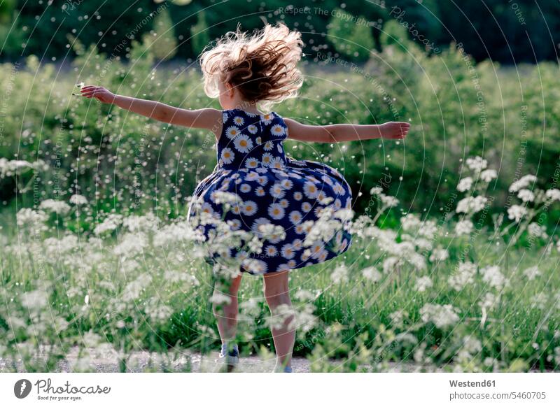 Little girl playing with seeds of blowball in nature dresses turn summer time summertime summery delight enjoyment Pleasant pleasure Emotions Feeling Feelings