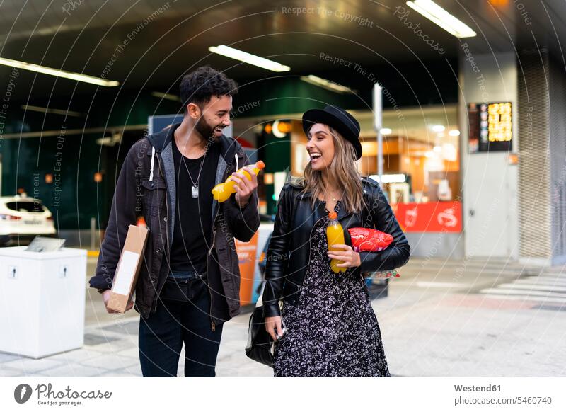 Laughing young couple with purchases in the city human human being human beings humans person persons caucasian appearance caucasian ethnicity european 2