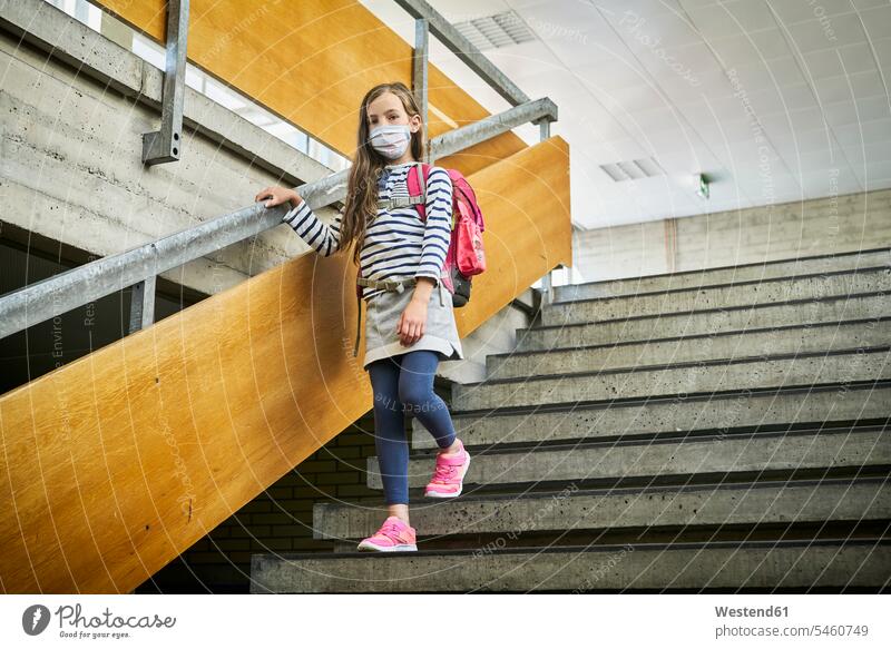 Girl wearing mask in school walking down stairs pupils schoolchild schoolchildren go going healthy protect protecting safe Safety secure buildings schools
