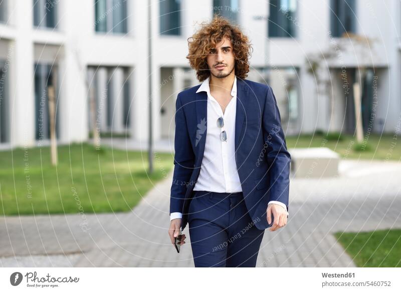 Portrait of young fashionable businessman with curly hair wearing blue suit Fullsuit suits full suit Businessman Business man Businessmen Business men curls
