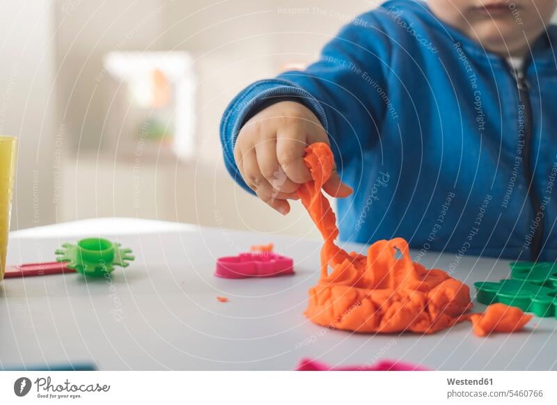 Hand of baby girl taking modeling clay, close-up putty plasticine modelling clay play clay play dough hand human hand hands human hands take baby girls female