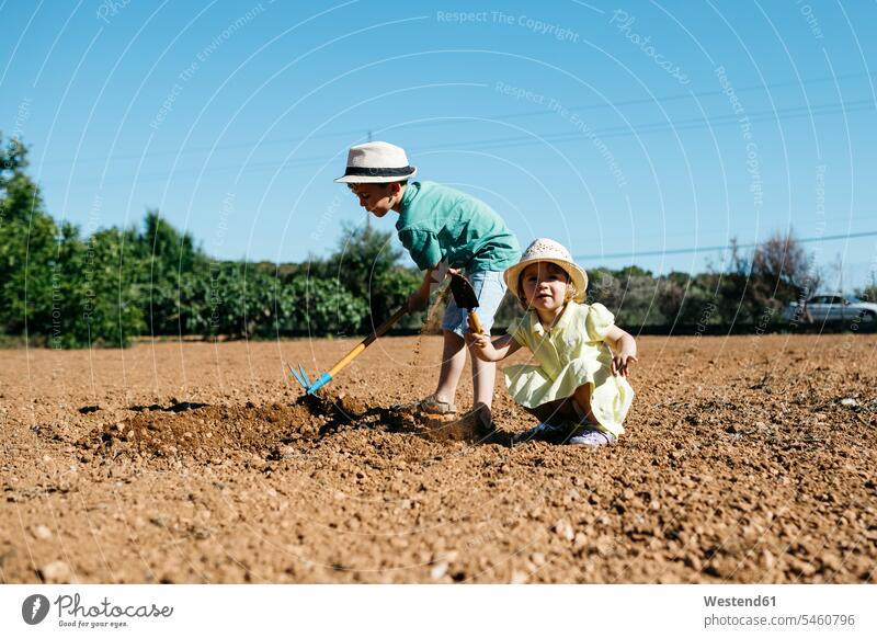 Boy and girl plowing the ground human human being human beings humans person persons caucasian appearance caucasian ethnicity european 2 2 people 2 persons two