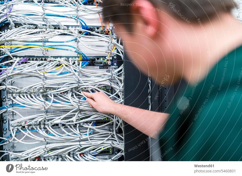 Close-up of teenager working with cables in server room At Work Teenage Boys male adolescent male adolescents male teenagers IT information technology Teenager