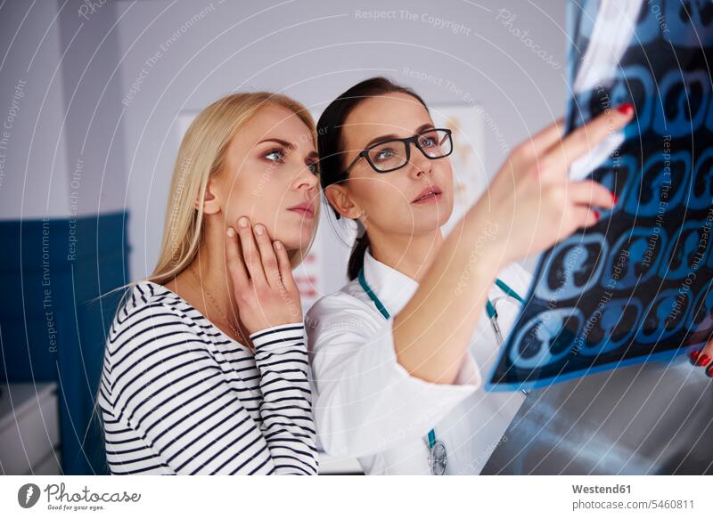 Doctor showing x-ray to young woman x-ray image x-rays radiography radiographies females women Female Doctor physicians Female Doctors Showing images picture