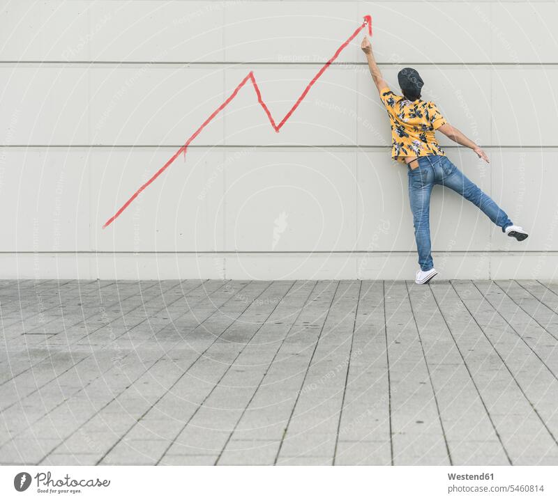 Digital composite of young man drawing a line graph at a wall human human being human beings humans person persons caucasian appearance caucasian ethnicity