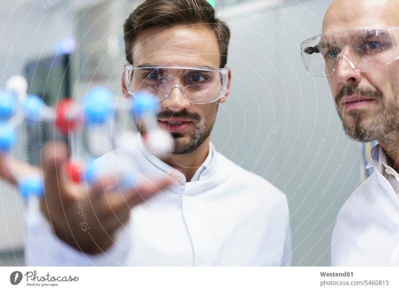 Confident male scientists analyzing molecular structure at illuminated laboratory color image colour image indoors indoor shot indoor shots interior