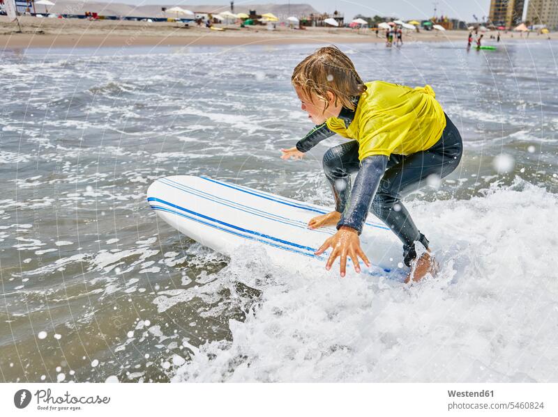 Chile, Arica, boy surfing in the sea boys males Sea ocean surf ride surf riding Surfboarding child children kid kids people persons human being humans
