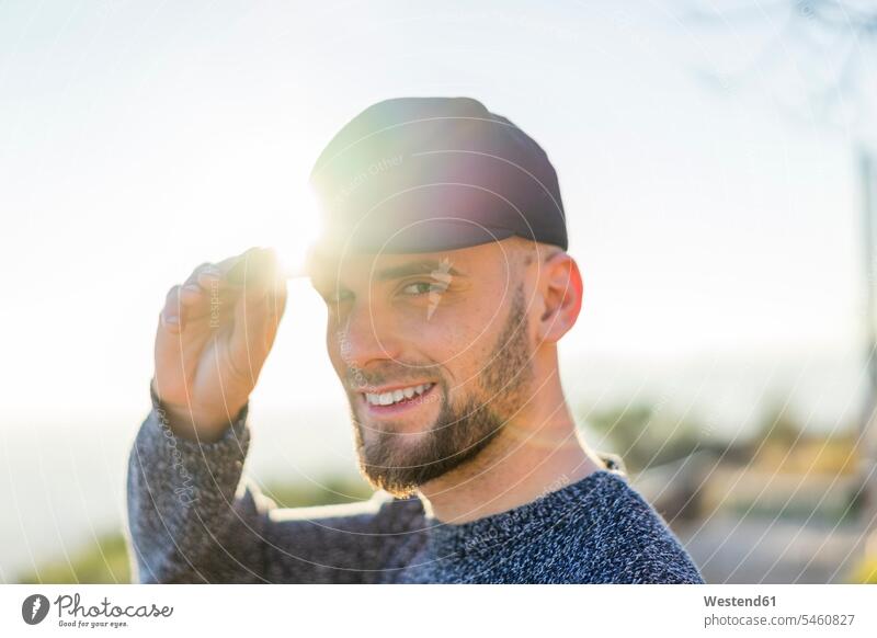 Portrait of smiling young man in backlight Backlit back light back lighting back lit portrait portraits men males smile Adults grown-ups grownups adult people