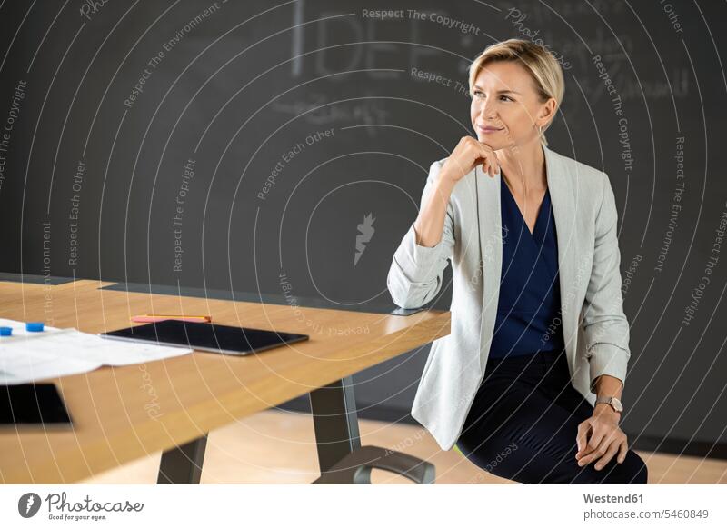 Confident blond businesswoman in conference room with blackboard Occupation Work job jobs profession professional occupation business life business world