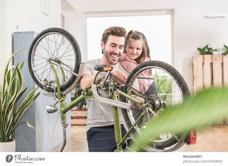 Young man and little girl repairing bicycle together Germany Quality Time Single Father Showing show one parent sustainability sustainable DIY do-it-yourself