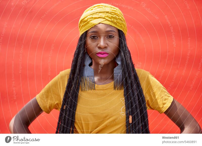 Portrait of woman in a long dreadlocks in front of a red wall human human being human beings humans person persons African black black ethnicity coloured 1