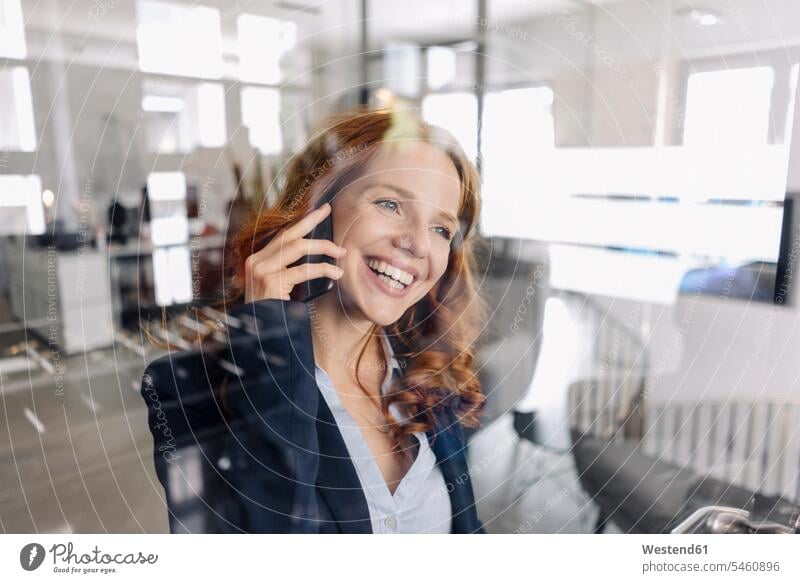 Happy redheaded businesswoman on the phone in office human human being human beings humans person persons caucasian appearance caucasian ethnicity european 1