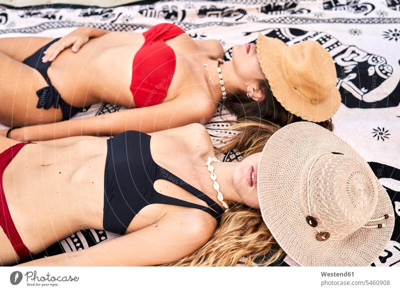 Two young women lying on a towel a beach human human being human beings humans person persons caucasian appearance caucasian ethnicity european 2 2 people