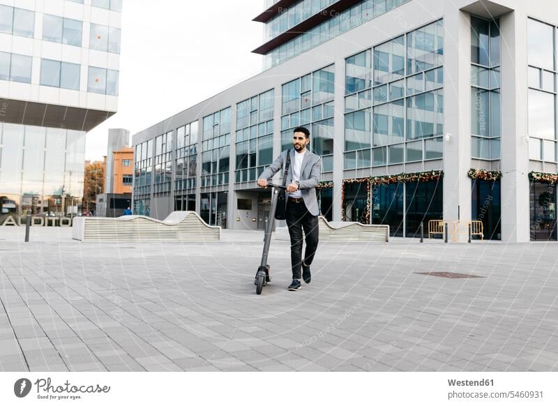 Casual young businessman pushing electric scooter in the city human human being human beings humans person persons 1 one person only only one person adult