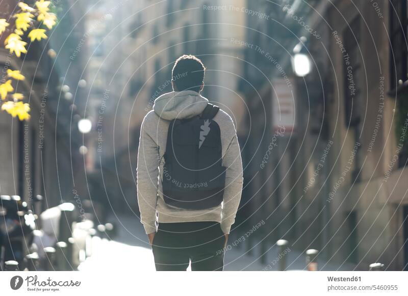 Man carrying backpack while standing with hands in pockets in city color image colour image outdoors location shots outdoor shot outdoor shots day daylight shot