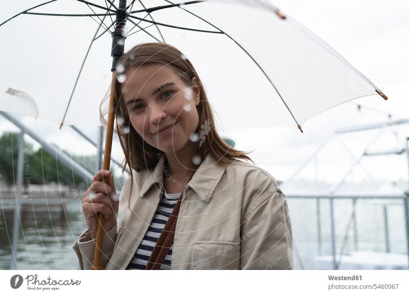 Close-up of smiling young woman with umbrella standing in city during rainfall color image colour image Netherlands Holland The Netherlands Nederland