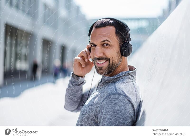Portrait of smiling man having a break from exercising wearing headphones exercise training practising men males smile portrait portraits headset Adults