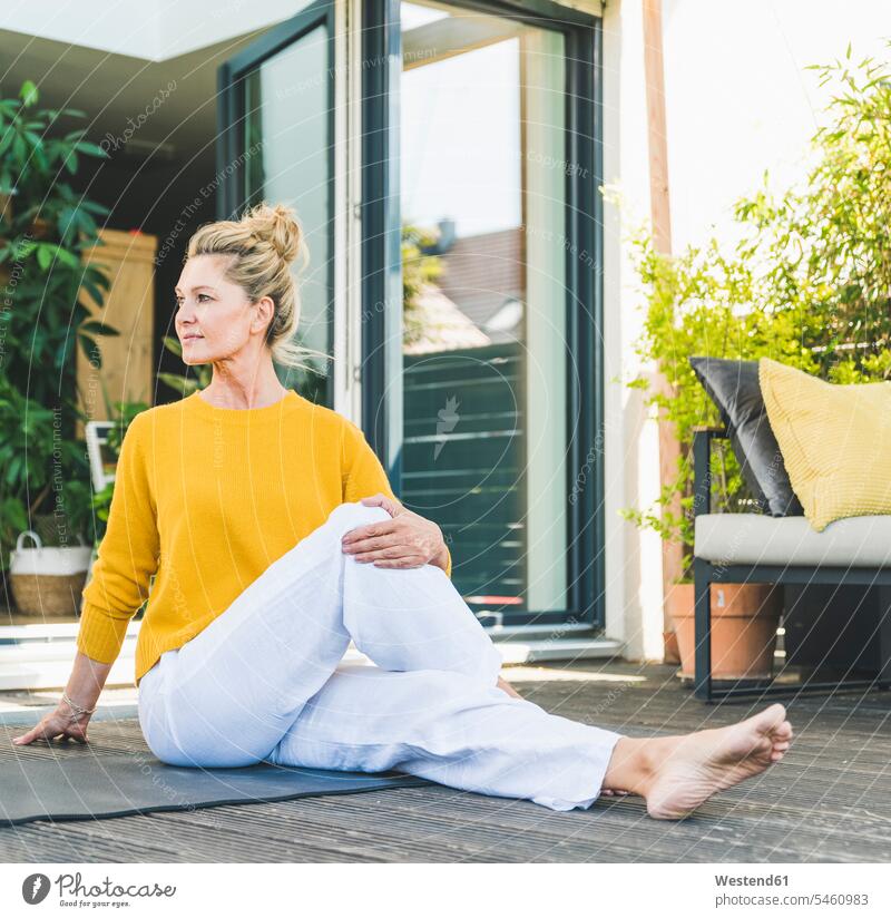 Mature woman doing yoga exercise on terrace jumper sweater Sweaters relax relaxing Seated sit colour colours at home free time leisure time Lifestyle