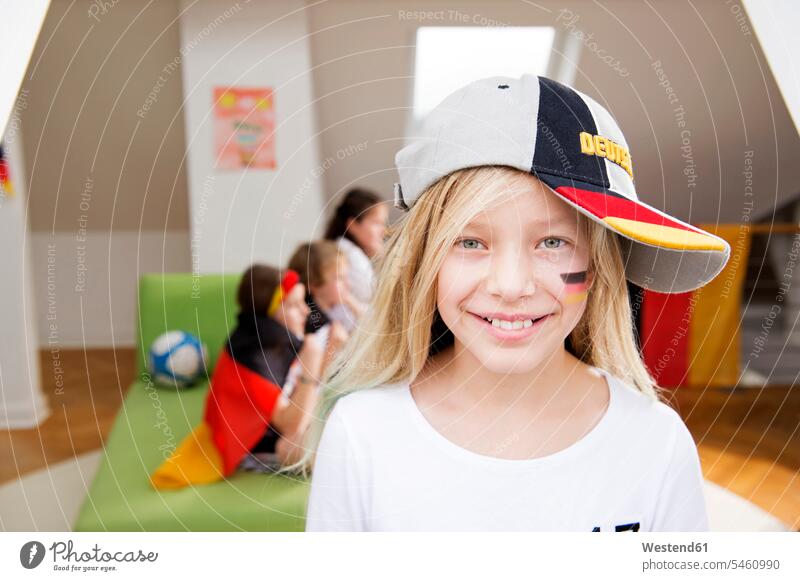 Portrait of a girl with German face paint and cap with friends in background Football World Cup Football World Championship home at home world cup