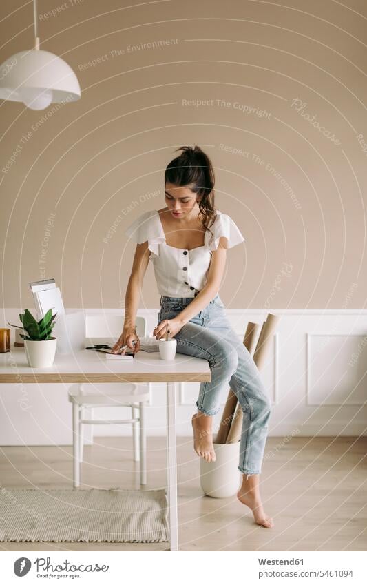 Young woman sitting on table at home human human being human beings humans person persons caucasian appearance caucasian ethnicity european 1 one person only