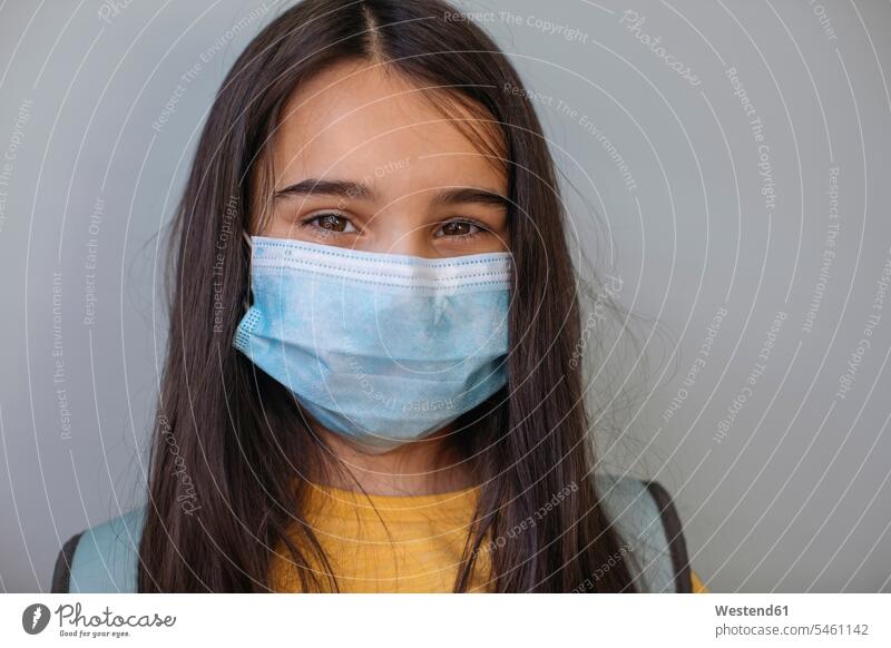 Girl with protective face mask standing against gray wall color image colour image indoors indoor shot indoor shots interior interior view Interiors day