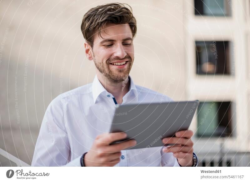 Smiling businessman in the city using tablet Businessman Business man Businessmen Business men digitizer Tablet Computer Tablet PC Tablet Computers iPad